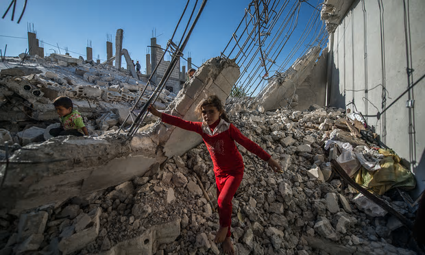 Children in the rubble in Jarablus, just south of Syria’s border with Turkey, on Saturday. [Image: Halil Fidan/Anadolu Agency/Getty Images].