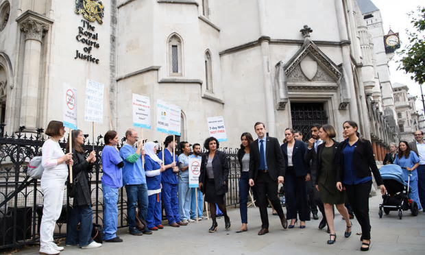 Doctors from Justice for Health walk past supporters outside the Royal Courts of Justice [Image: Leon Neal/Getty Images].